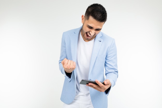 Portrait of a man with a phone in his hands playing games on a white background.