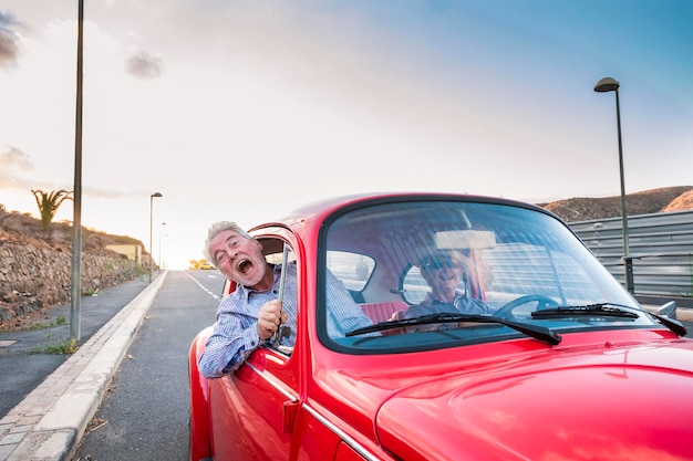 portrait of man with woman peeking from car window against sky
