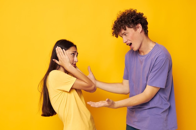 友情の楽しみをポーズするカラフルなTシャツの男性と女性の肖像画孤立した背景は変更されていません