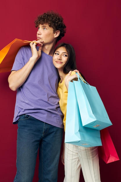 한 남자와 한 여자가 손에 들고 있는 쇼핑백의 초상화는 변하지 않은 배경입니다. 고품질 사진