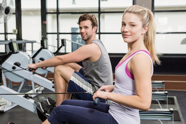 Portrait of a man and woman working out on rowing machine