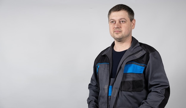 Photo portrait of a man in working overalls on a white background