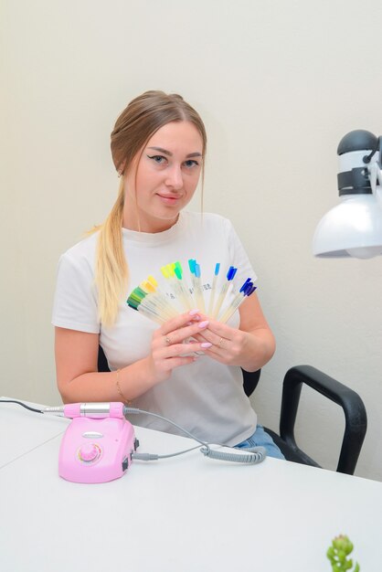 portrait of a manicure master in the salon at the workplace with tools in his hands