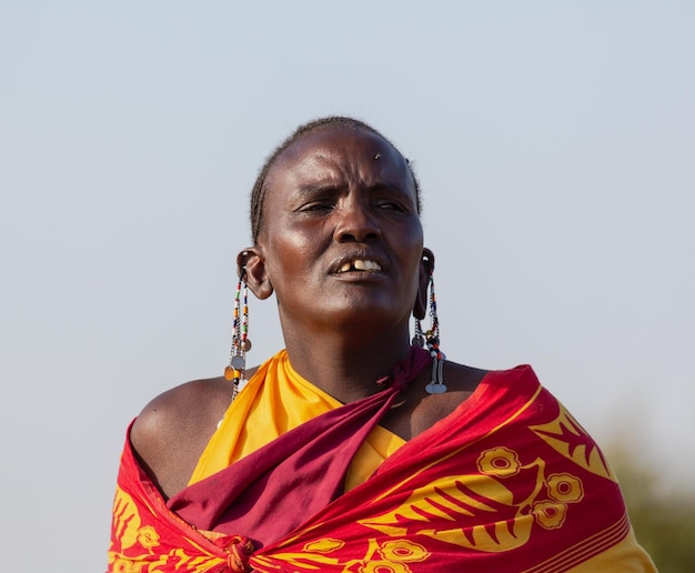 歌を歌っている伝統的な服を着たマサイマラ女性の肖像画。マサイマラ、ケニア