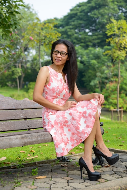 Portrait of mature Asian woman relaxing at the park outdoors