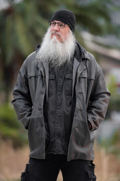 Portrait of mature bearded hipster man with eyeglasses thinking