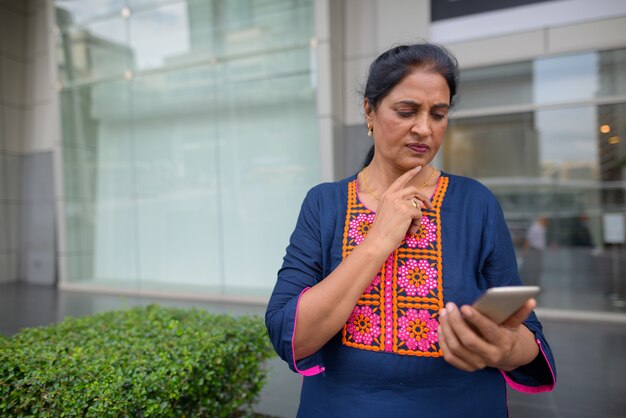 Portrait of mature beautiful Indian woman exploring the city of Bangkok, Thailand