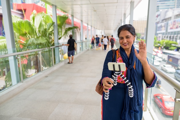 Portrait of mature beautiful Indian woman exploring the city of Bangkok, Thailand