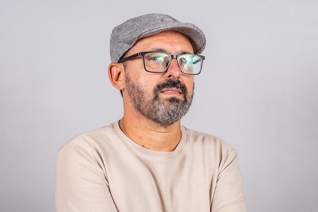 Portrait of mature businessman wearing eyeglasses over gray background Happy 60s senior brazilian man looking at camera isolated over gray wall with copy space