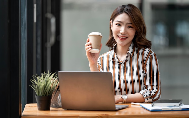 Portrait of mature businesswoman sitting at desk smiling to camera