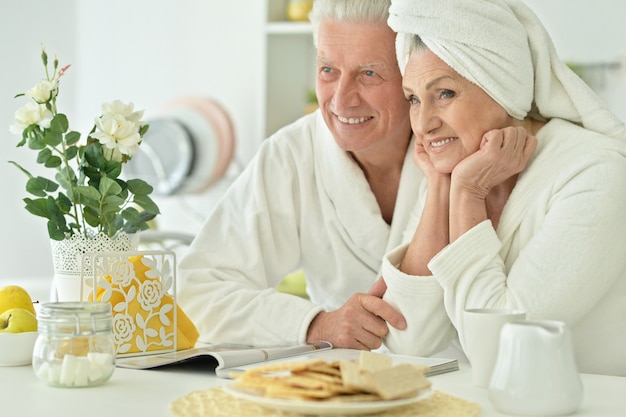 Portrait of mature couple in a bathrobe at kitchen