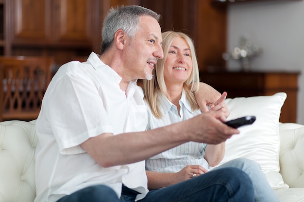 Portrait of a mature couple watching television