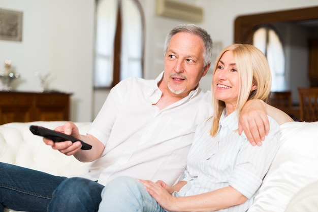 Portrait of a mature couple watching television