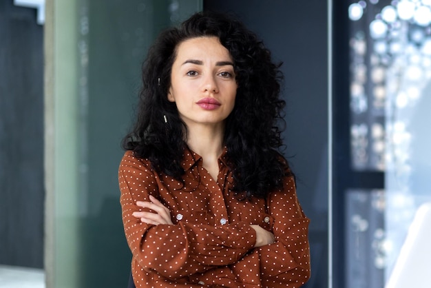 Portrait of mature female boss inside office building successful hispanic woman looking serious at