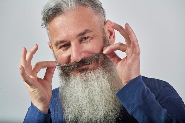 Portrait of mature gray-haired bearded man in blue sweatshirt