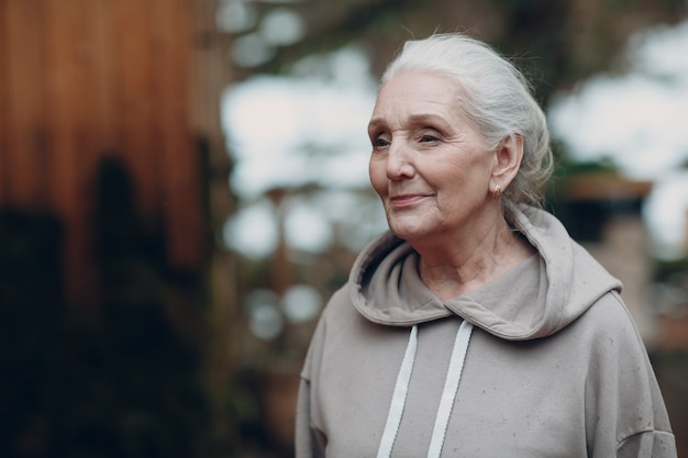 Photo portrait of mature gray haired elderly older woman outdoor