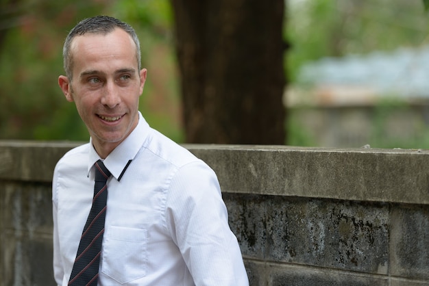 Portrait of mature handsome casual businessman in the streets outdoors