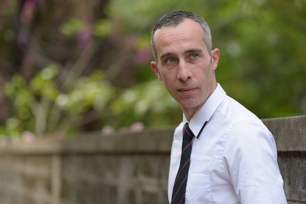 Portrait of mature handsome casual businessman in the streets outdoors