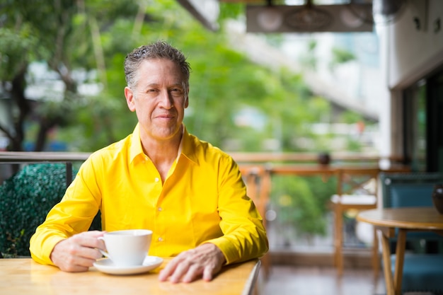 Portrait Of Mature Handsome Man Sitting In Coffee Shop