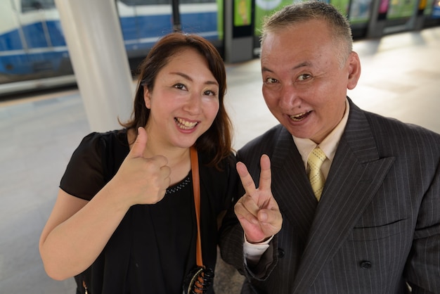 Portrait of mature Japanese businessman and mature Japanese woman exploring the city of Bangkok