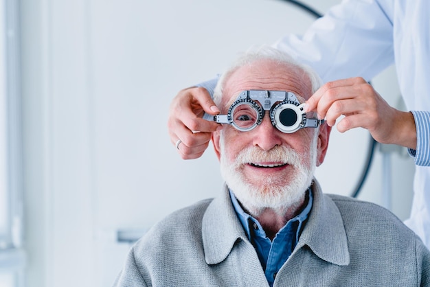 Photo portrait of a mature man fitting ophthalmic spectacles with doctors help