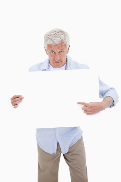 Portrait of a mature man pointing at a blank board