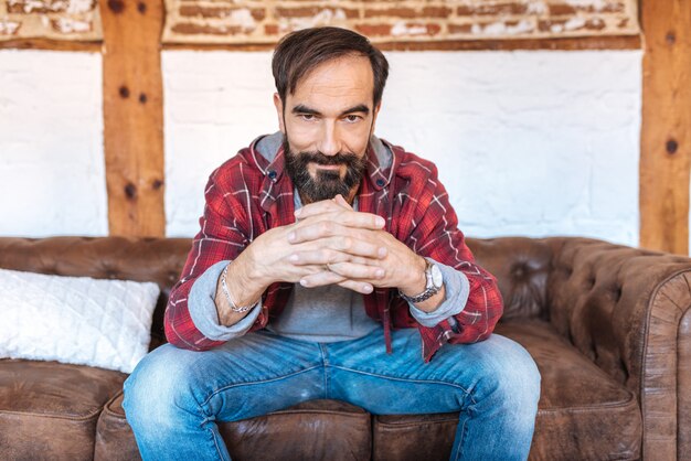 Portrait of a mature man sitting on the couch posing thoughtful