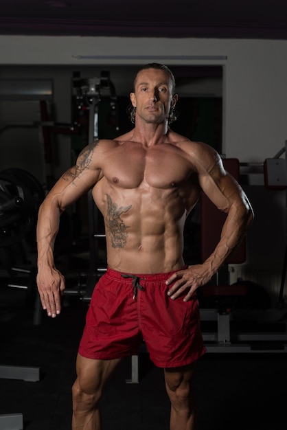 Portrait Of A Mature Physically Fit Tattoo Man Showing His Well Trained Body  Muscular Athletic Bodybuilder Fitness Model Posing After Exercises