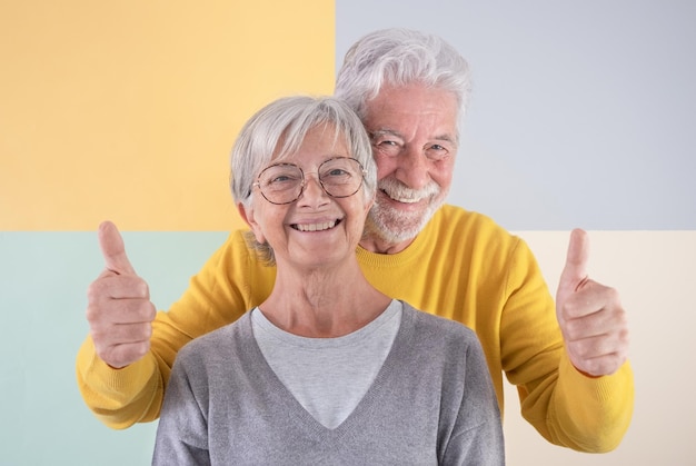 Portrait of mature smiling senior couple standing over isolated background looking at camera