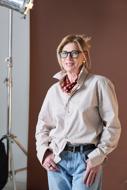 Portrait of mature stylish businesswoman in casual clothing smiling at camera while standing at office