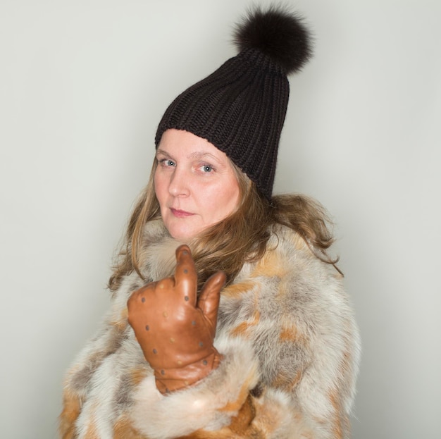 Photo portrait of mature woman gesturing while standing against gray background