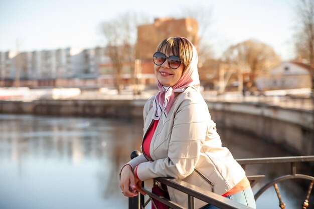 Portrait of mature woman in headscarf and sunglasses on city street