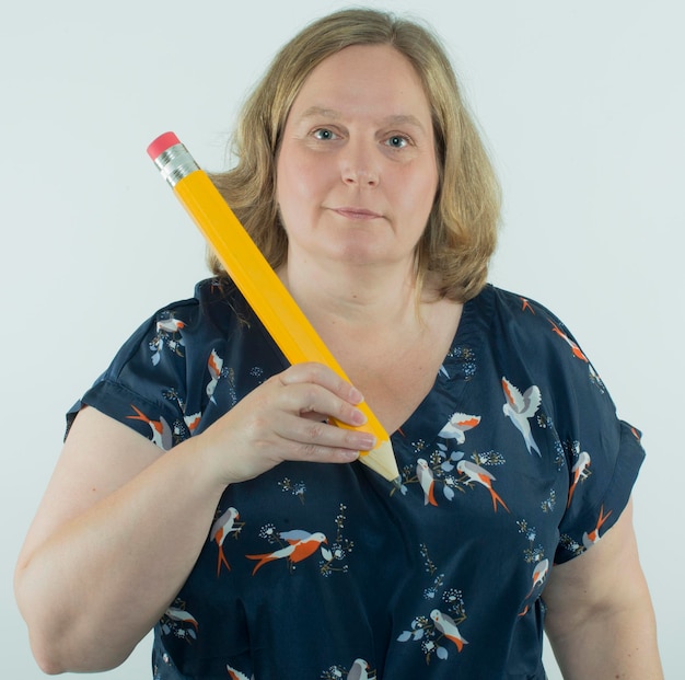 Photo portrait of mature woman holding large brush against white background