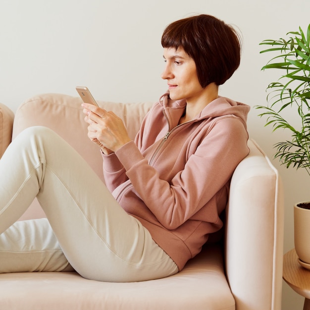 Portrait of mature woman looking social media on mobile phone middle aged female