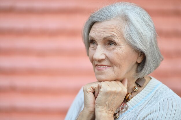 Portrait of a mature woman near wall on street