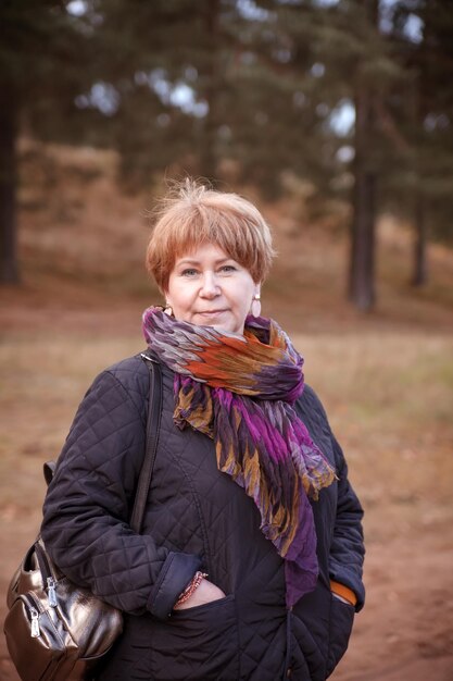 Portrait of mature woman in spring jacket on walk in park