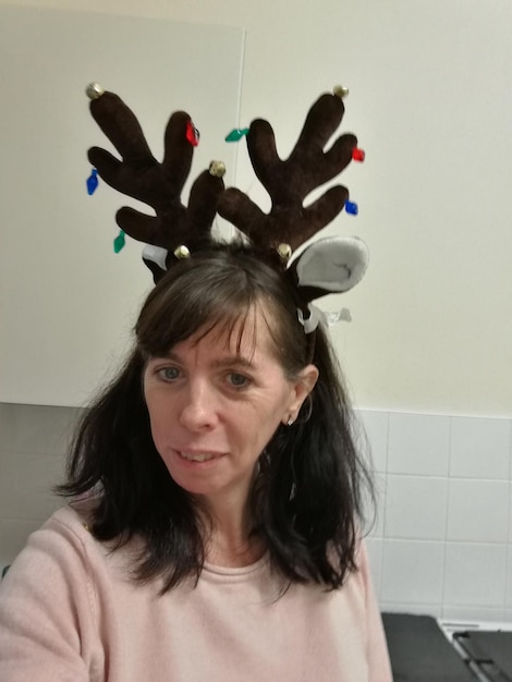 Photo portrait of mature woman wearing costume reindeer antlers