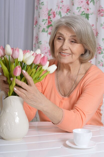 Portrait of mature woman with flowers drinking tea