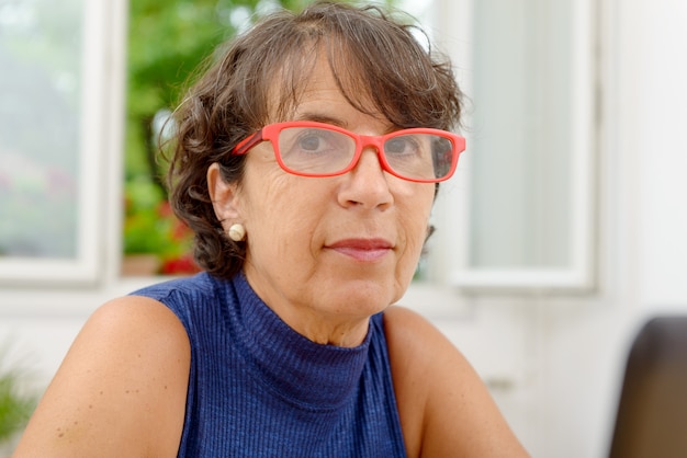 Portrait of a mature woman with red glasses