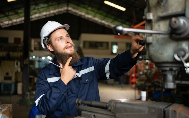 Photo portrait of mechanical engineers are checking the working condition of an old machine