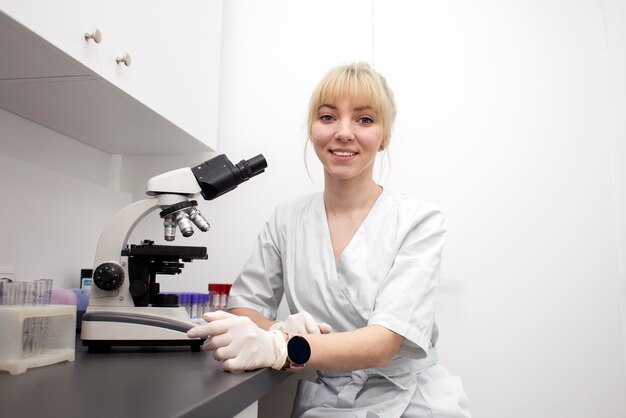 Portrait of a medical laboratory worker in uniform at the workplace a young girl doctor