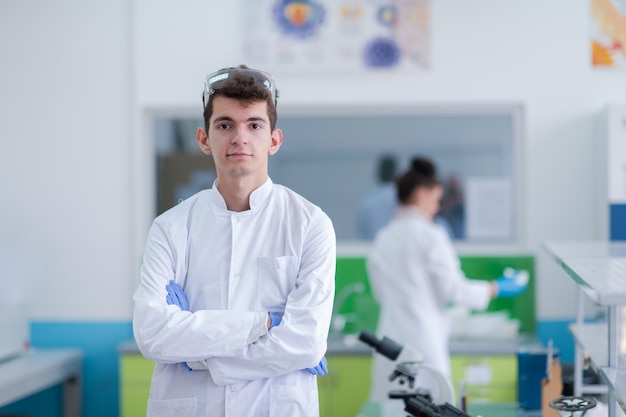 Photo portrait of medical student in white coat while standing in chemistry laboratory