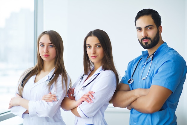 Portrait of medical team standing with arms crossed in hospital