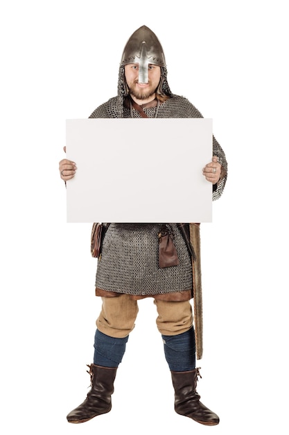 Portrait of medieval slavic knight holding a blank notepad white board signboard showing an empty billboard against white studio background historical concept