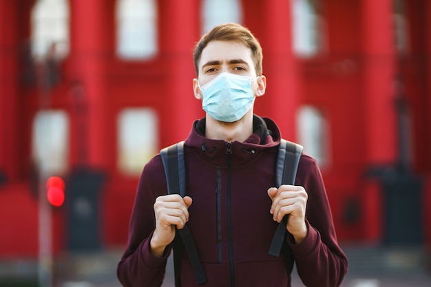 Portrait of men in protective sterile medical mask on her face on the street city. Covid-19.