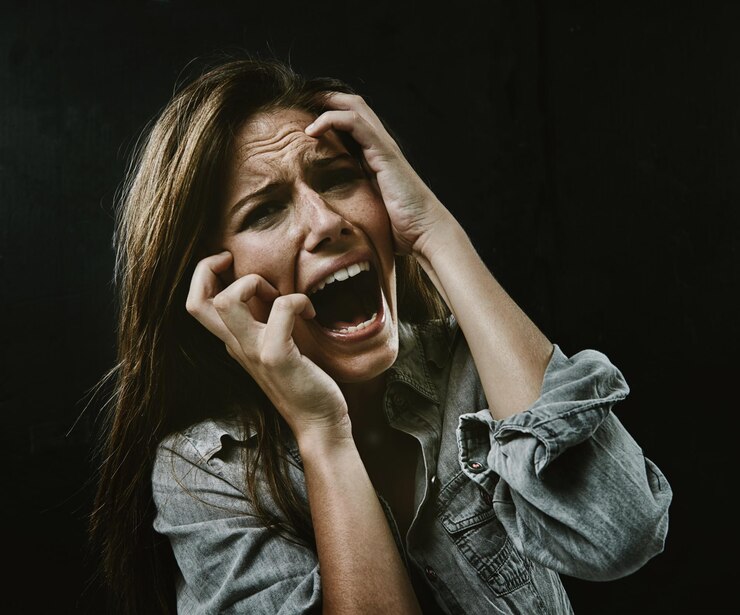 फोटो portrait mental health and horror with woman screaming in studio on black background for reaction to fear face anxiety and stress with scared young person in dark for drama nightmare or terror