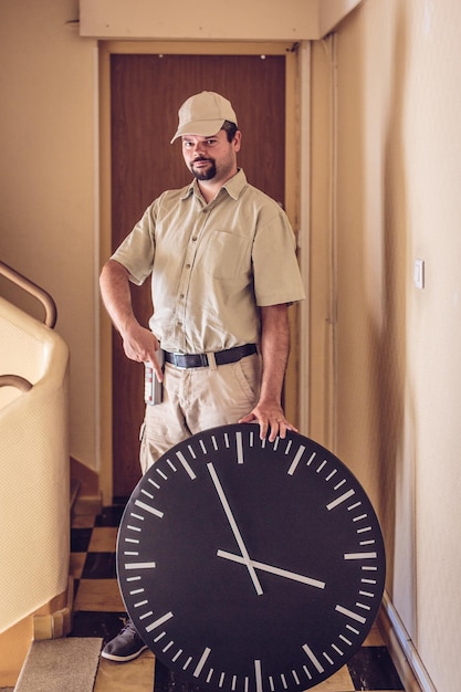 Foto ritratto di un messaggero con un orologio in piedi nell'edificio