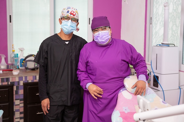 Portrait of a Mexican female dentist and her assistant  smiling