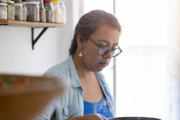 Portrait of a Mexican real woman cooking in the kitchen