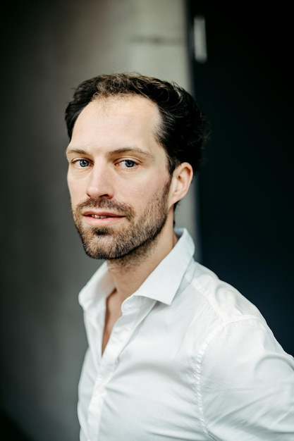 portrait of mid adult man standing against wall